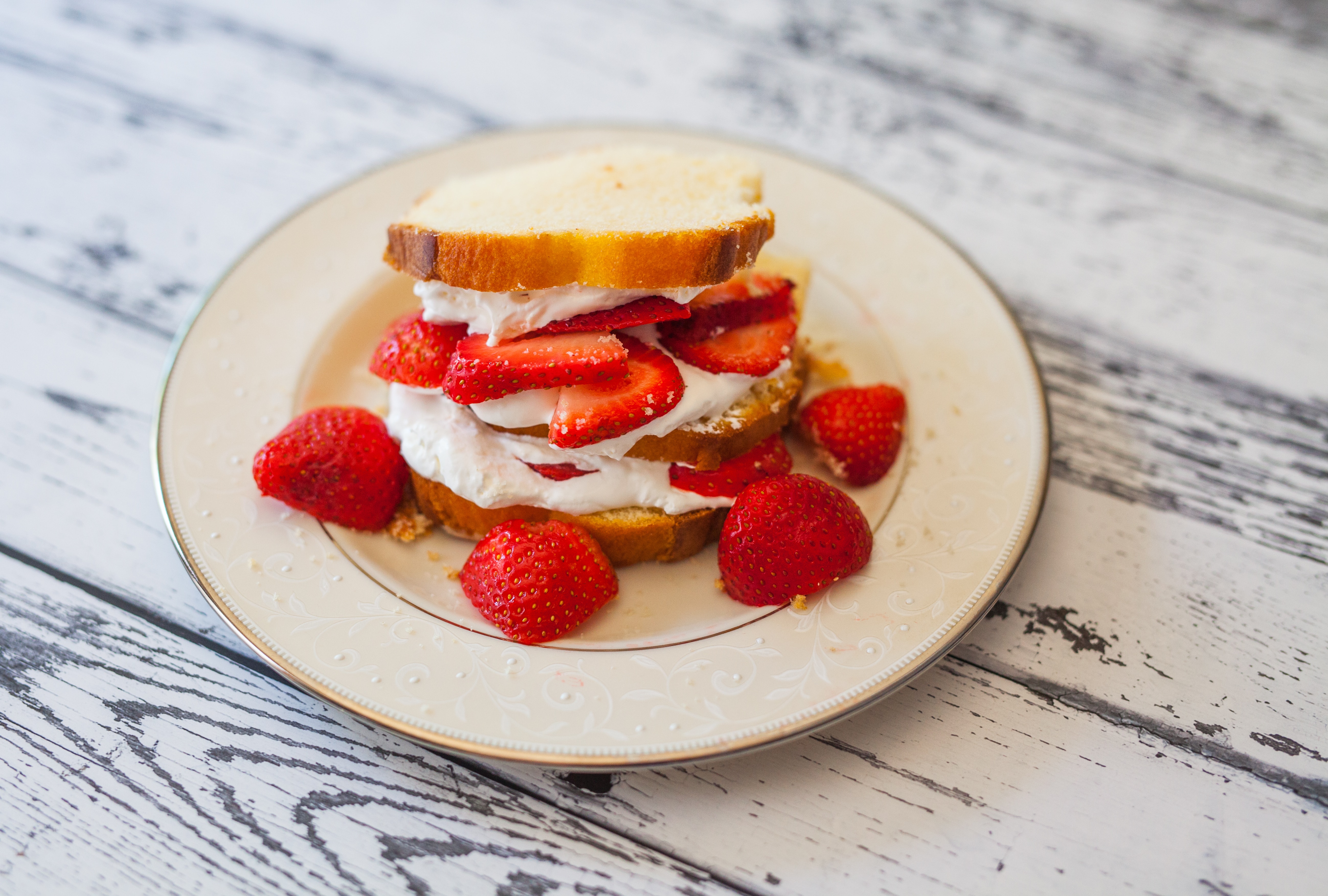 shortcake with cream and strawberry slices on plate